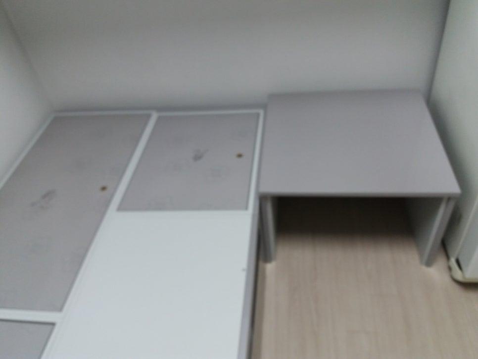 회색 상판과 화이트 수납장, 회색 테이블이 배치된 모습