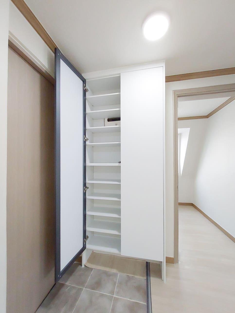 베이지색 매트가 깔린 드레스룸 내부 모습
