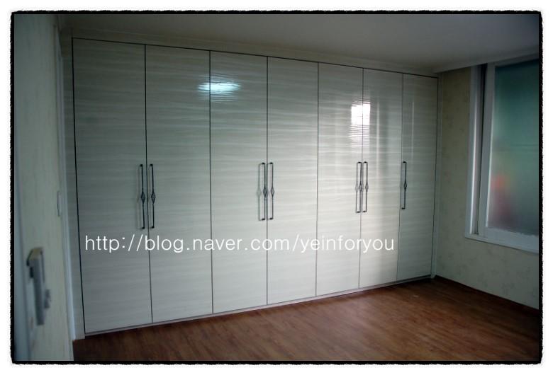 화이트 텍스처와 금속 핸들이 조화로운 드레스룸