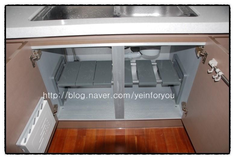 주방 싱크대 아래 수납장과 배관이 보이는 시공 현장