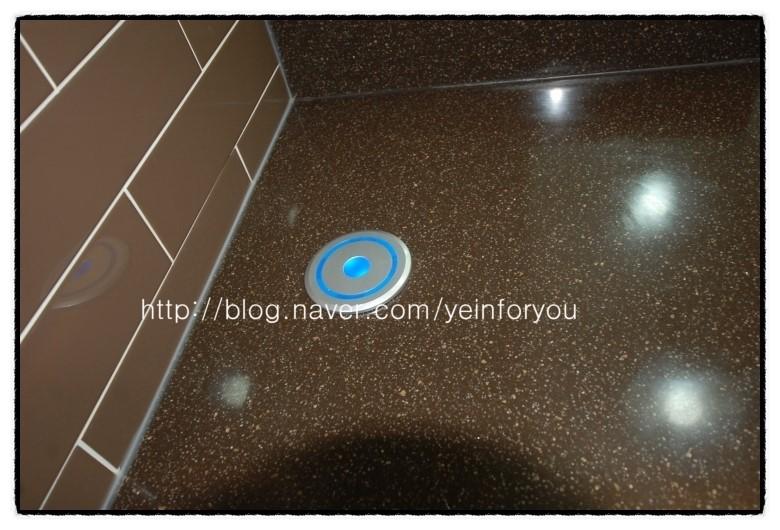 검은색 타일 바닥 위 파란 빛 원형 버튼이 보이는 과정샷