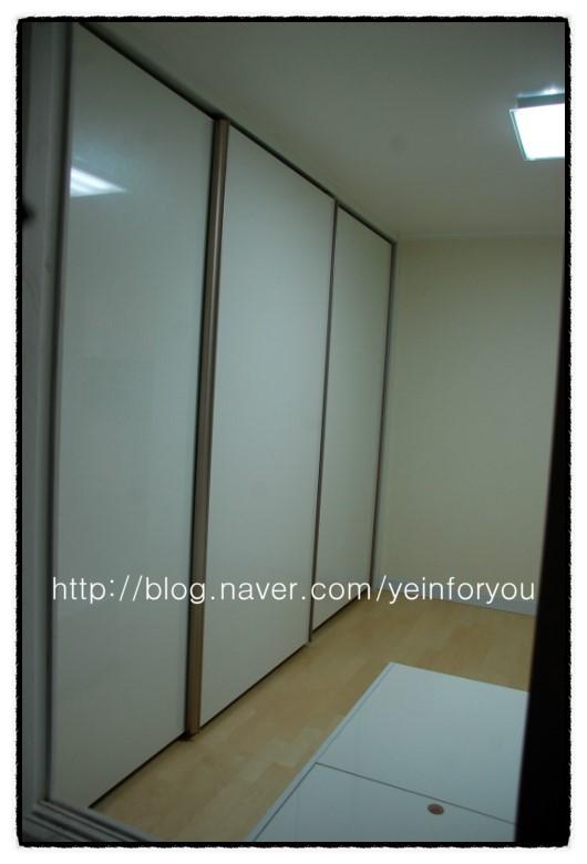천장 조명 아래 정렬된 세 개의 흰색 슬라이딩 도어
