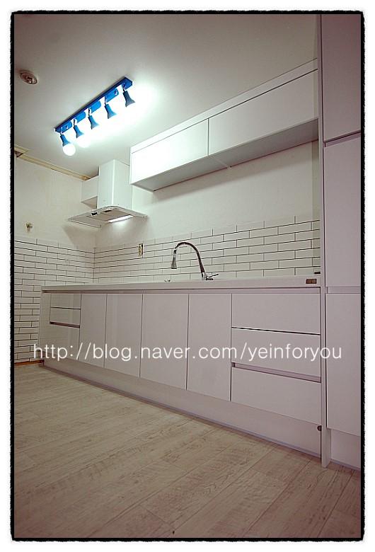 목재 바닥과 화이트 수납장이 어우러진 모습