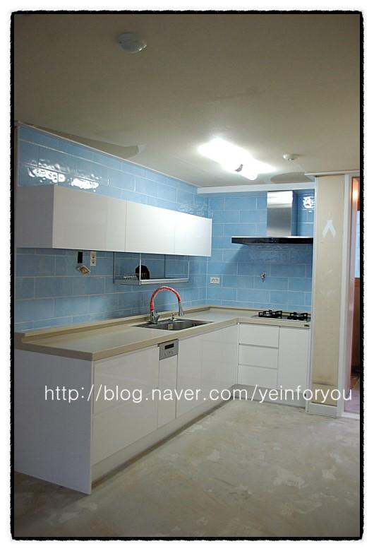 파란색 타일 벽면과 화이트 수납장의 대비