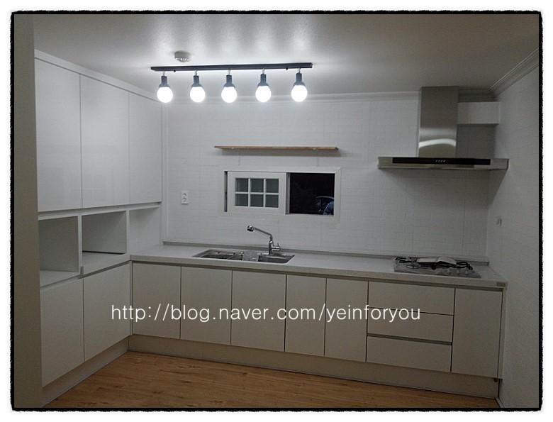 화이트 벽돌 타일과 조명으로 완성된 밝은 주방