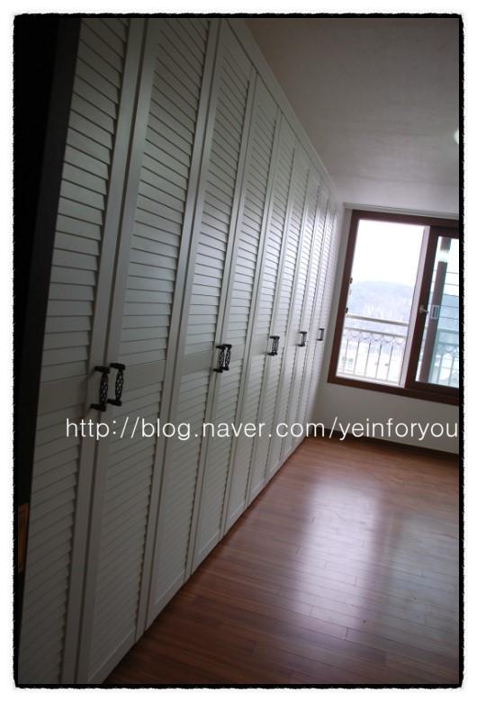 우드톤 바닥과 조화를 이루는 설치 완료된 수납장