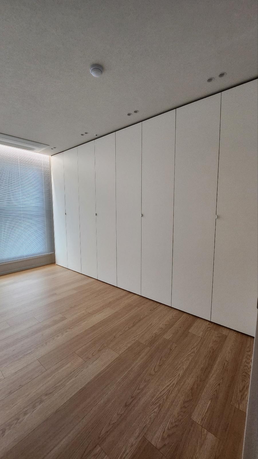 자연광이 머무는 밝은 우드 바닥과 붙박이장