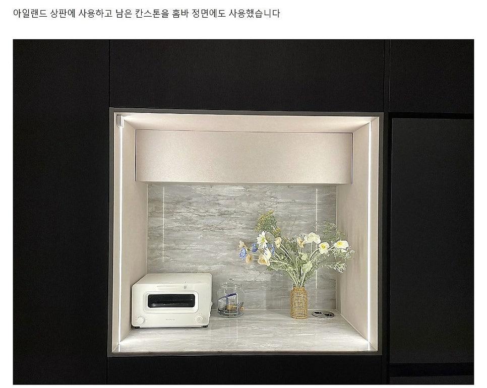 검은색 벽면과 회색 타일이 매치된 주방 내부 모습