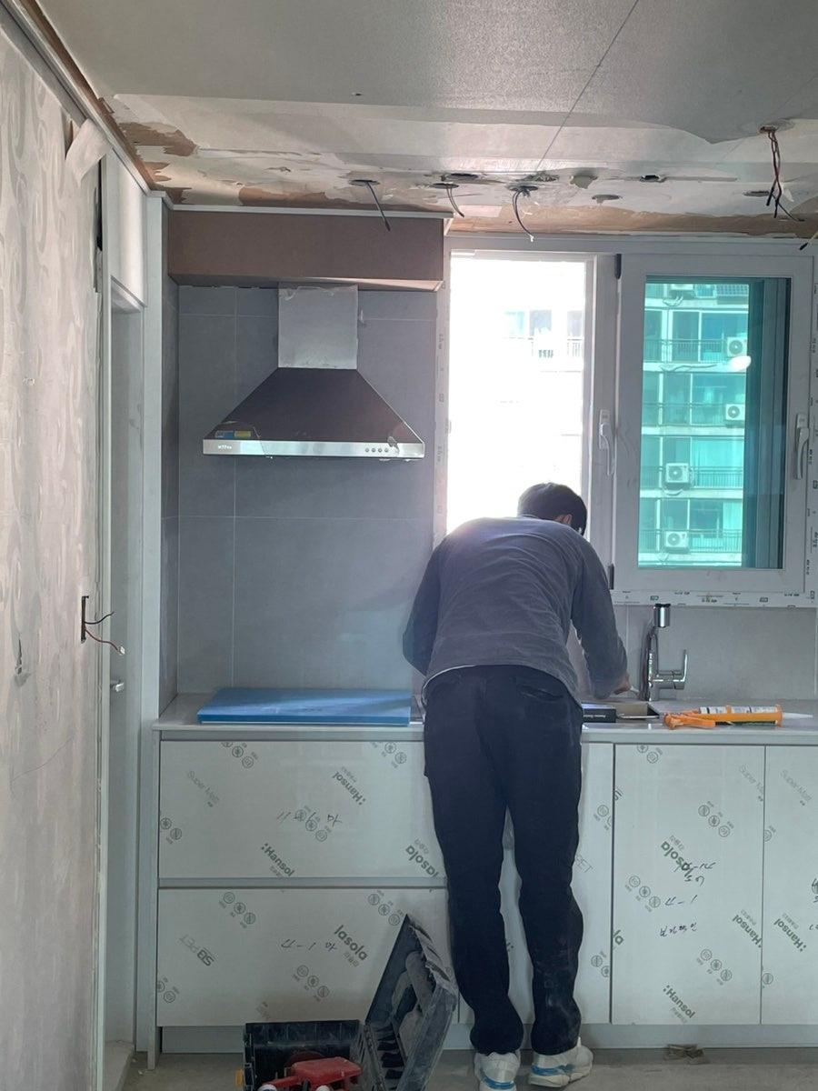 브라운 타일과 흰색 캐비닛이 보이는 주방 현장