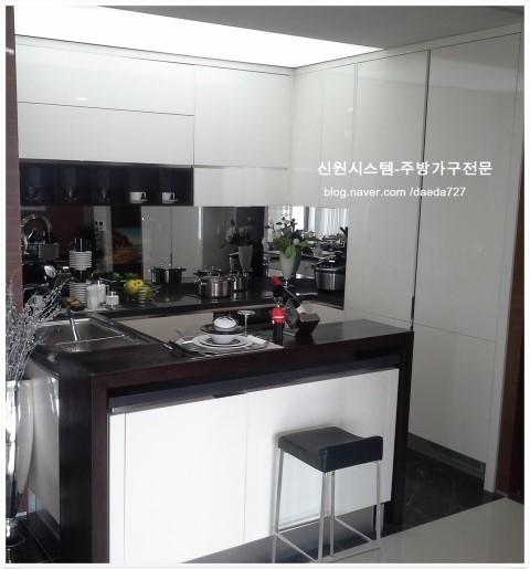 화이트 상판과 블랙 싱크대가 대비되는 주방 모습