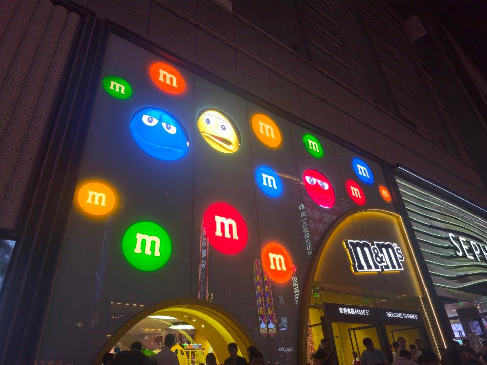 조명으로 밝혀진 M&M 매장 외벽 로고