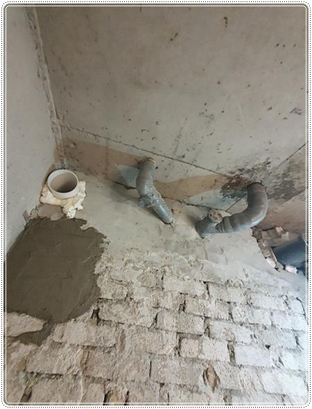 금속 배관이 노출된 상태에서 진행 중인 타일 및 조적 공사 현장