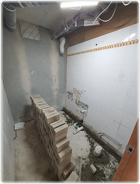 벽돌 조적 작업과 배관 설비가 진행 중인 철거 현장