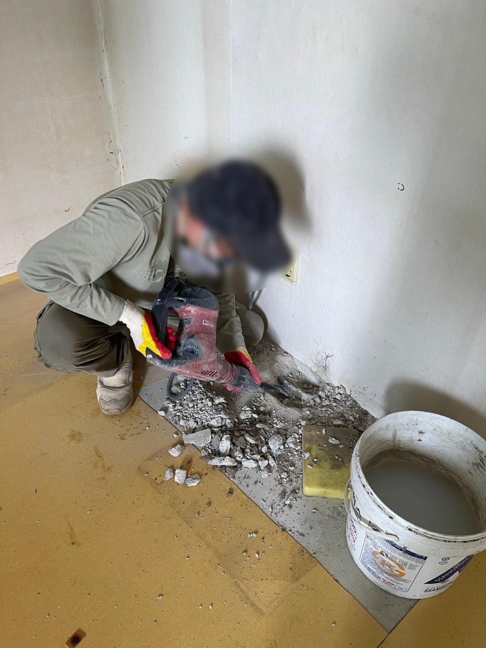 잔해물을 정리 중인 실내 벽과 바닥 현장