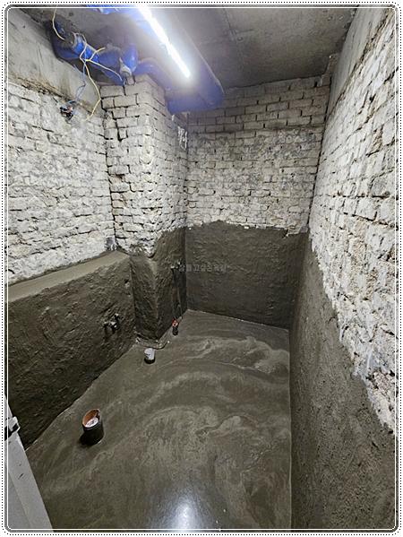 물이 고여 있는 콘크리트 바닥과 노출 배관