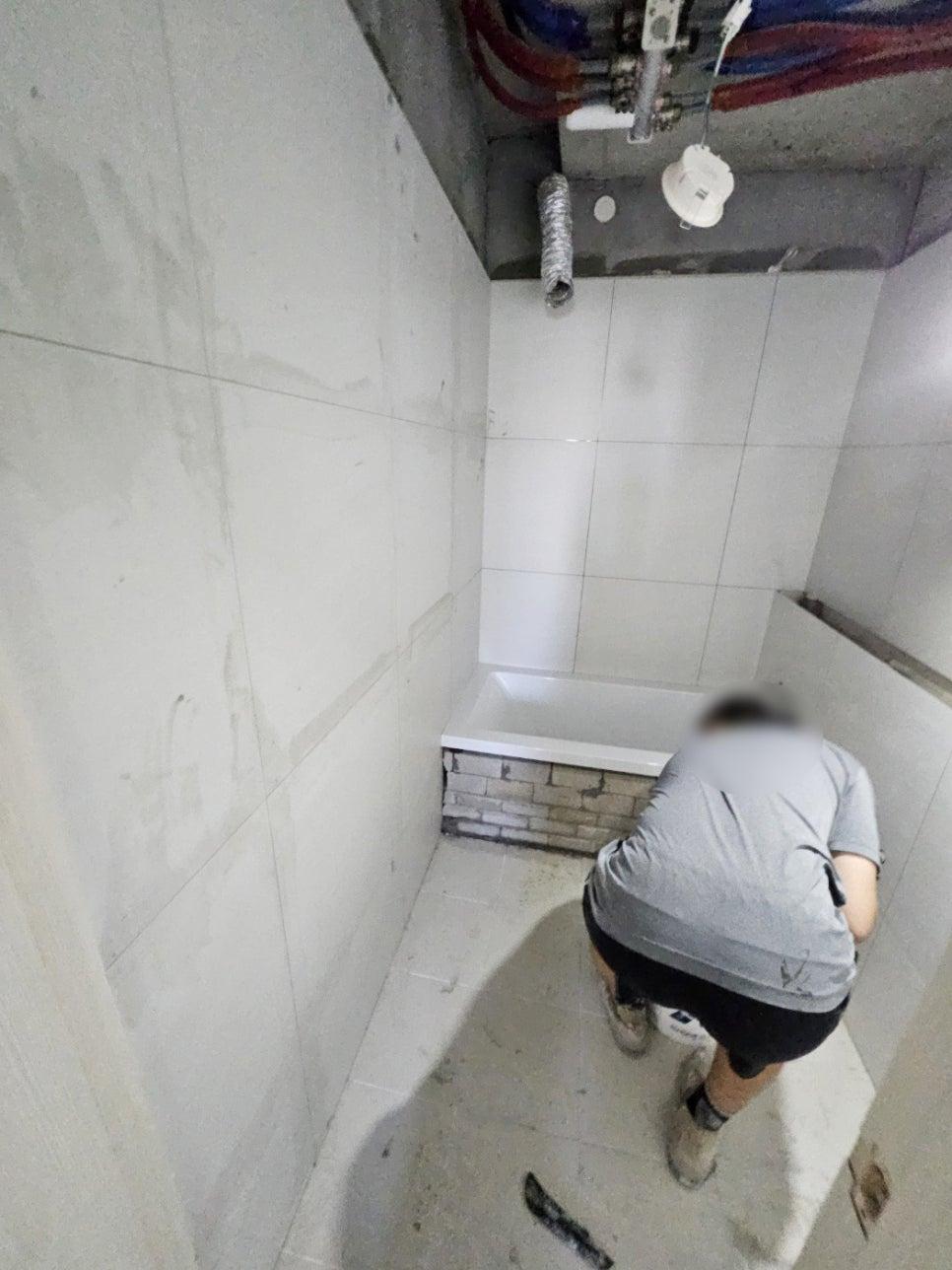 설비 위치를 고려하며 타일을 시공하는 모습