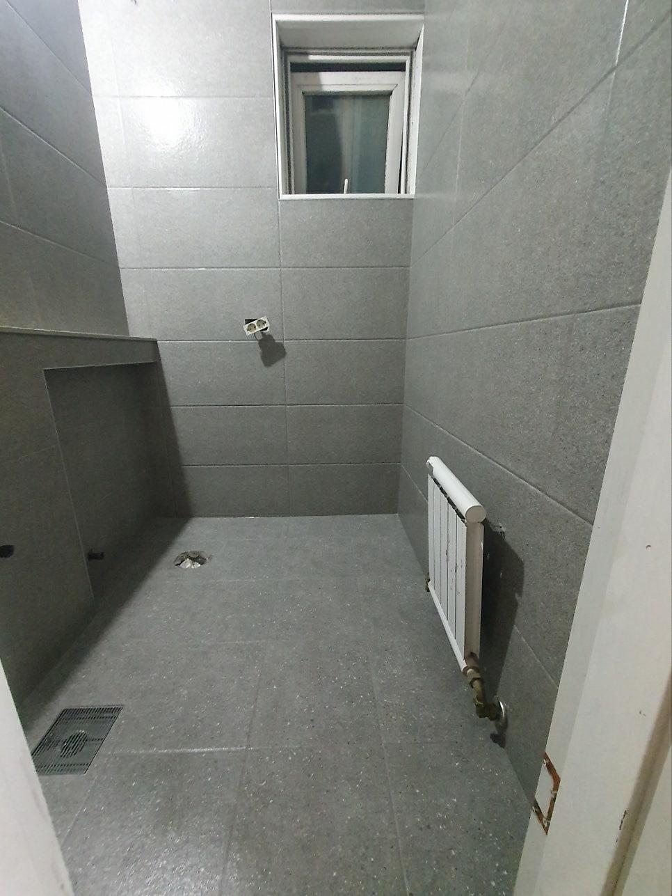 회색 타일로 마감되어 창호가 설치된 빈 공간