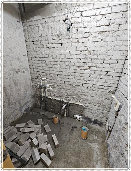 배관과 전선이 노출된 벽돌 벽면과 바닥
