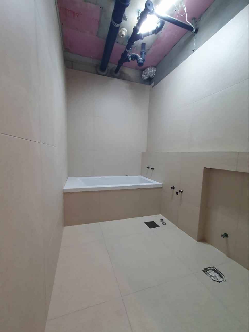 욕조 주변의 설비 상태를 점검하는 장면
