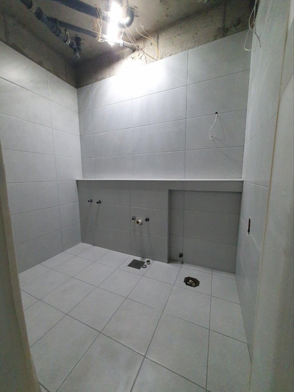 벽과 바닥 타일 시공이 완료된 텅 빈 욕실