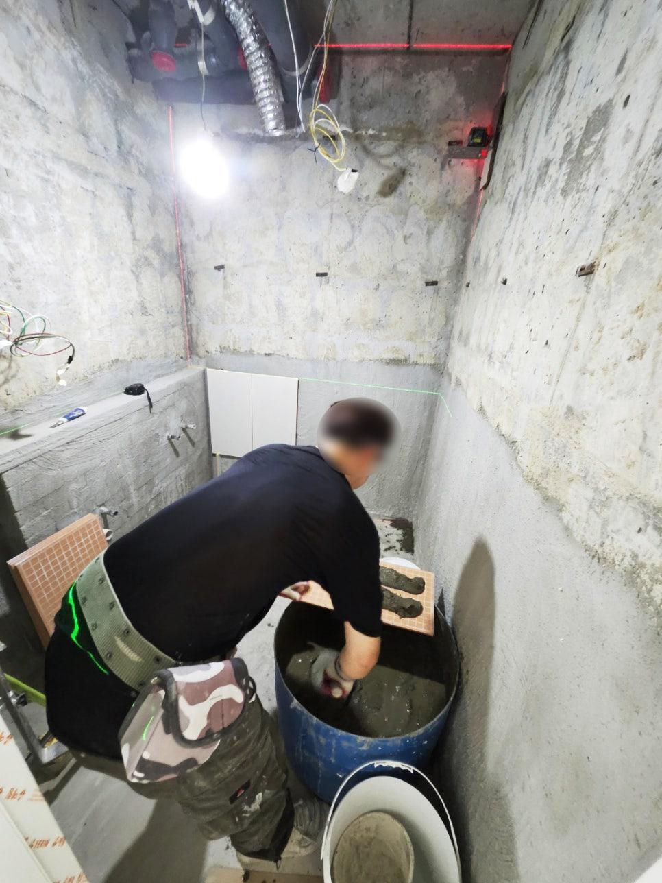 파란 통에 혼합물을 담아 방수 작업을 하는 장면