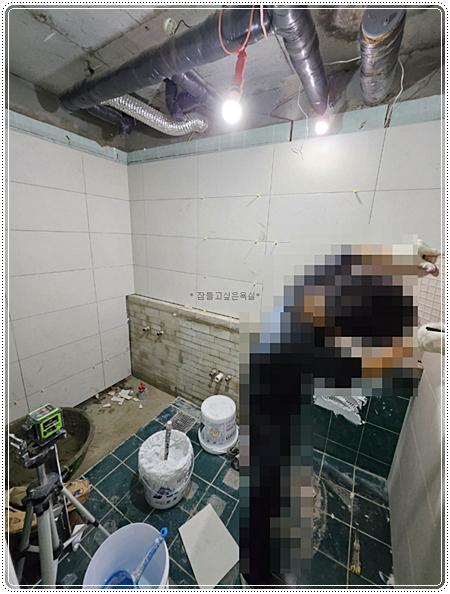벽 타일 부착 작업이 진행 중인 모습