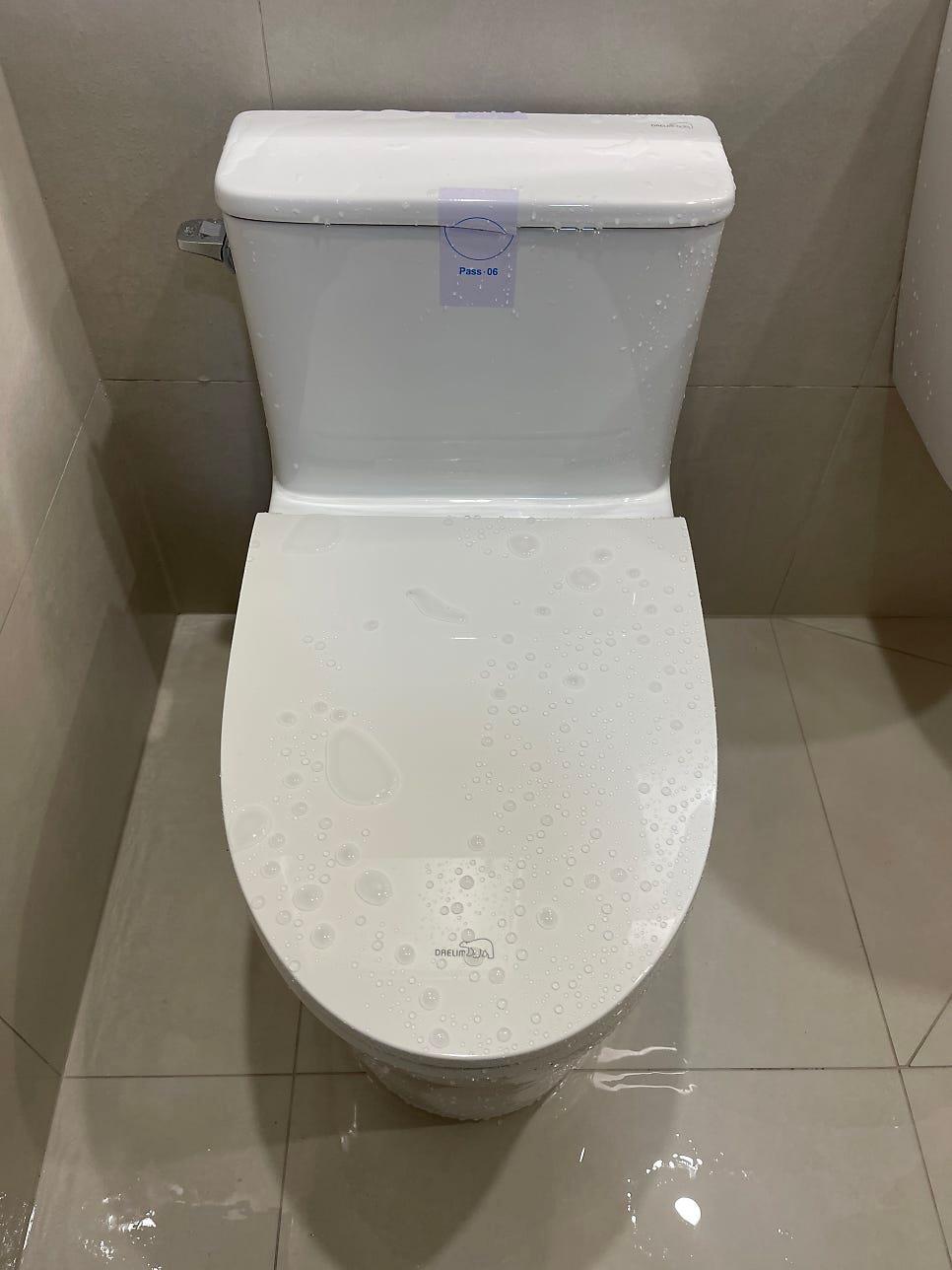 타일 마감된 벽면의 화이트 변기와 세면대