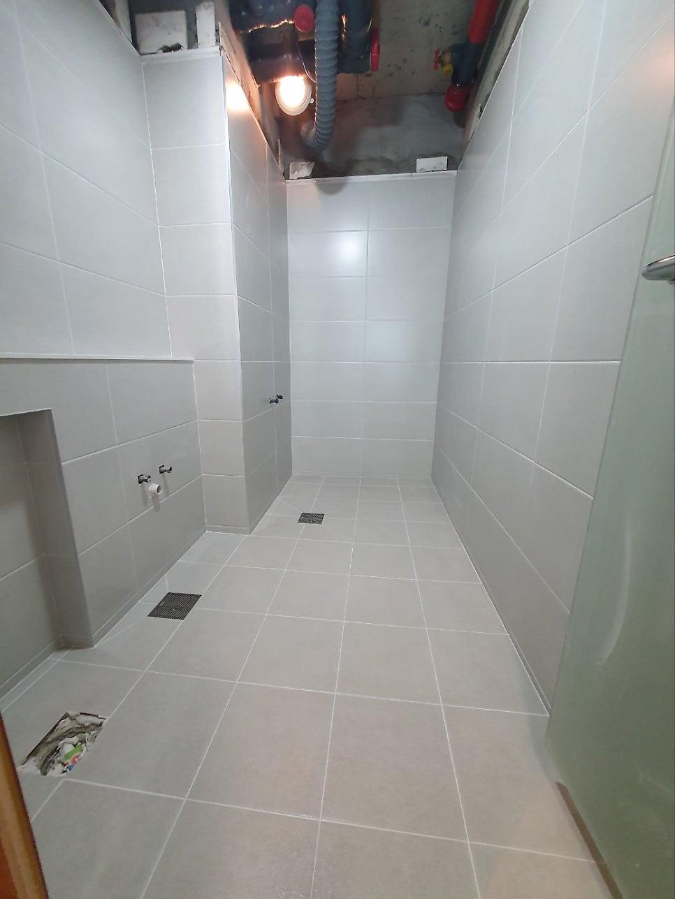 배수구와 조명 배선이 보이는 마감 전 단계