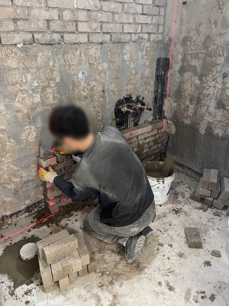 벽면에 브릭을 붙이고 있는 작업 과정