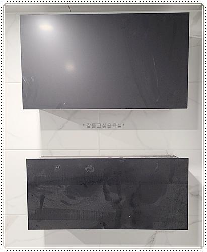 화이트 타일 바닥과 블랙 TV 월이 배치된 거실