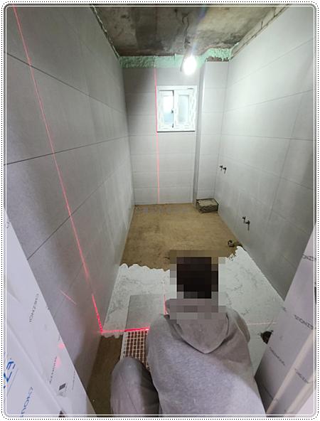 회색 타일로 벽면을 채워가는 시공 단계