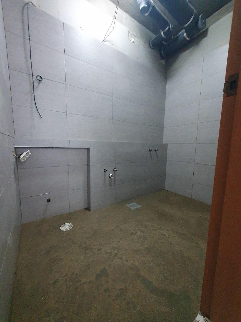 천장 배관이 노출된 텅 빈 욕실 내부
