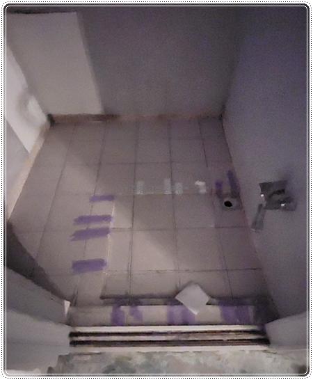 보라색 테이프가 붙은 타일 바닥과 배수구 주변