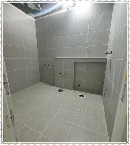 벽 타일 부착 공사가 진행 중인 장면