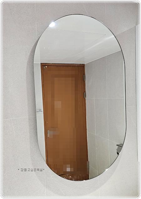 거울에 반사된 벽면 타일과 문