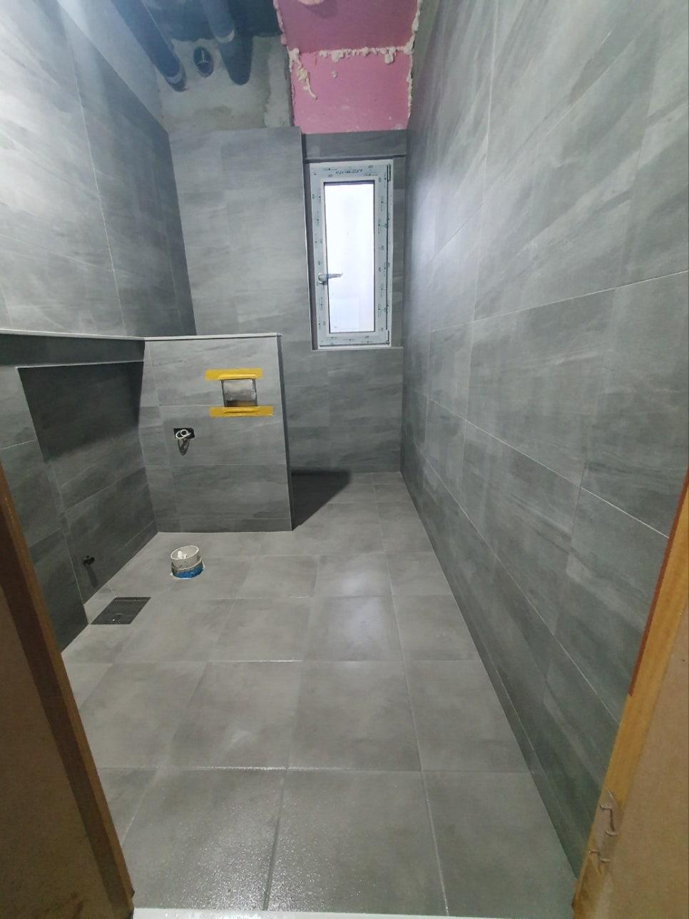 회색 타일이 마감된 벽면과 작은 창문