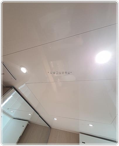 화이트 톤 천장 조명과 유리 패널이 설치된 마감 모습