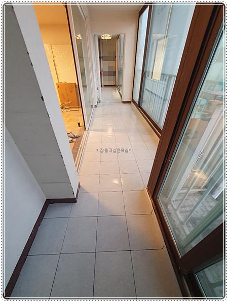흰색 타일 바닥과 유리문이 설치된 복도 공간