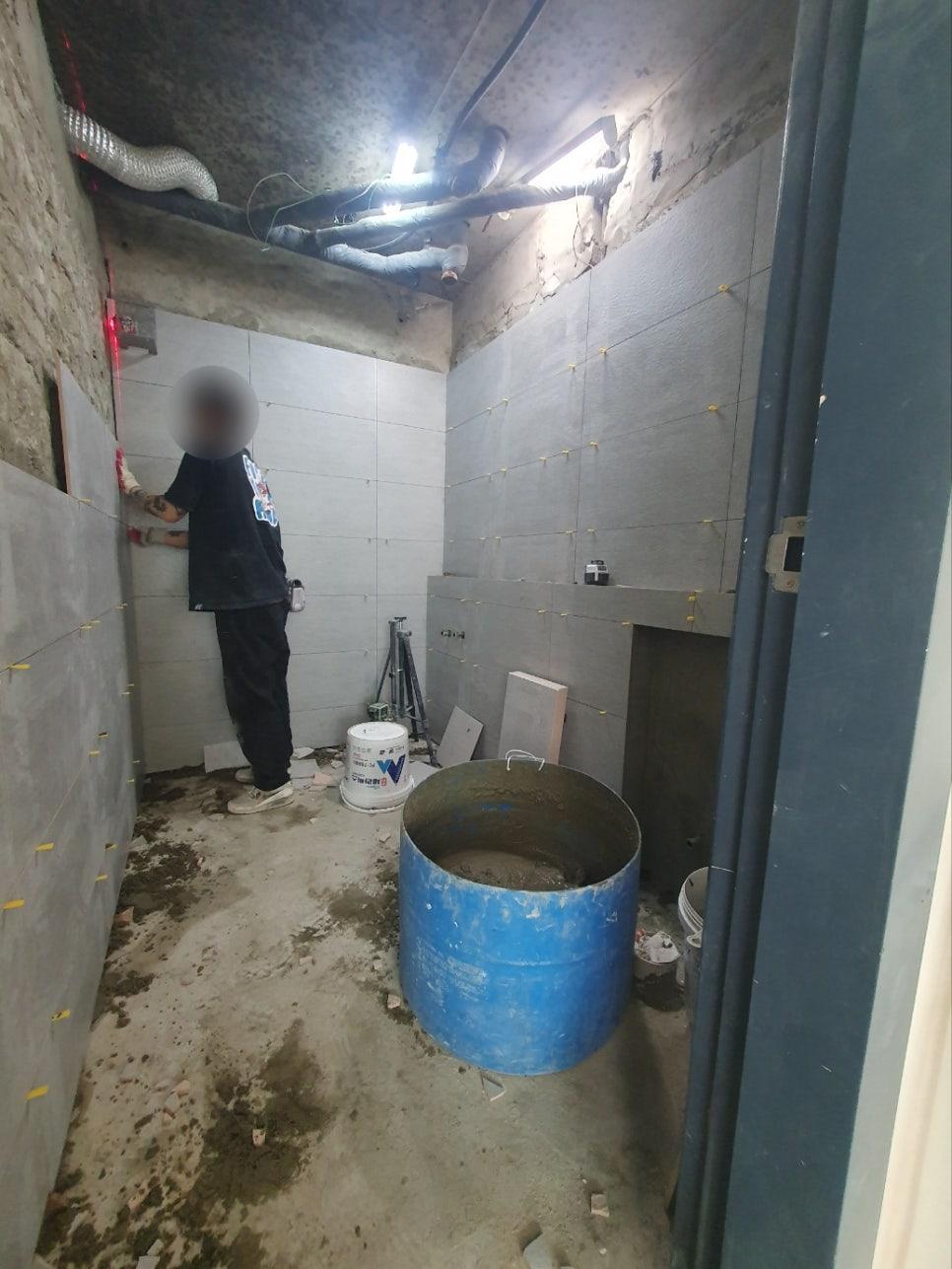 벽면에 타일을 부착하고 있는 작업 장면
