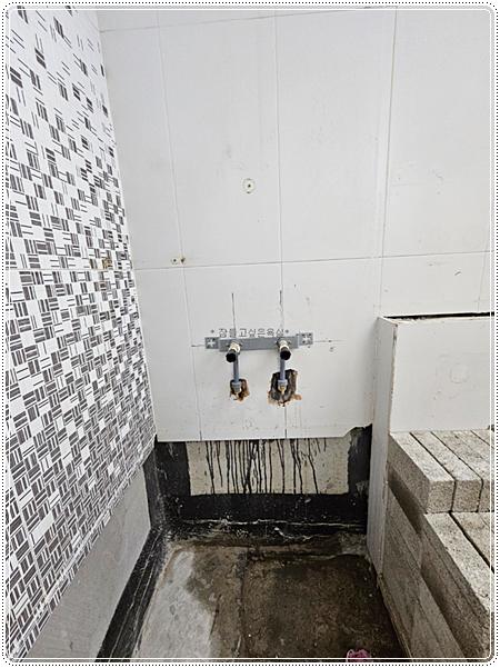 수도관이 노출된 타일 벽면의 시공 초기 상태
