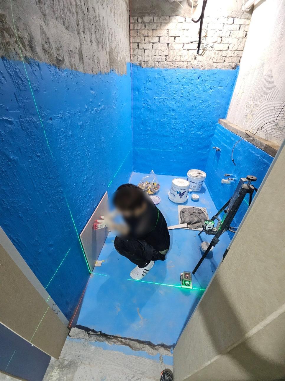 파란색 마감층 위로 진행 중인 타일 작업