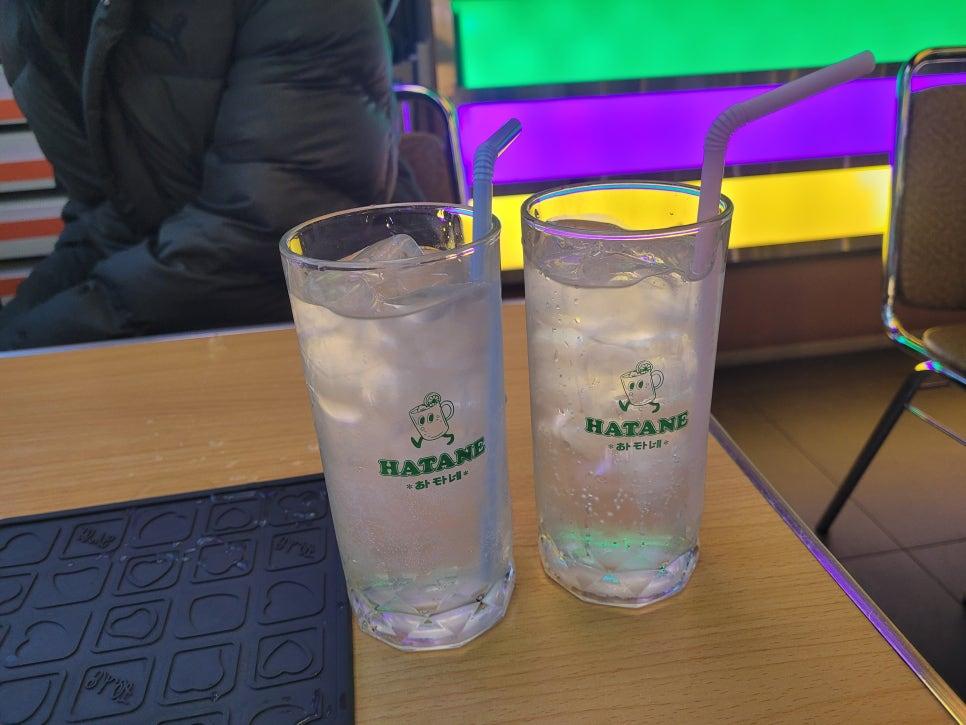 조명 아래 HATANE 로고 잔이 놓인 준비 과정
