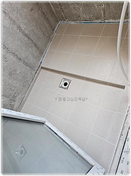사각 점검구와 샤워 설비가 보이는 욕실 천장 및 벽면