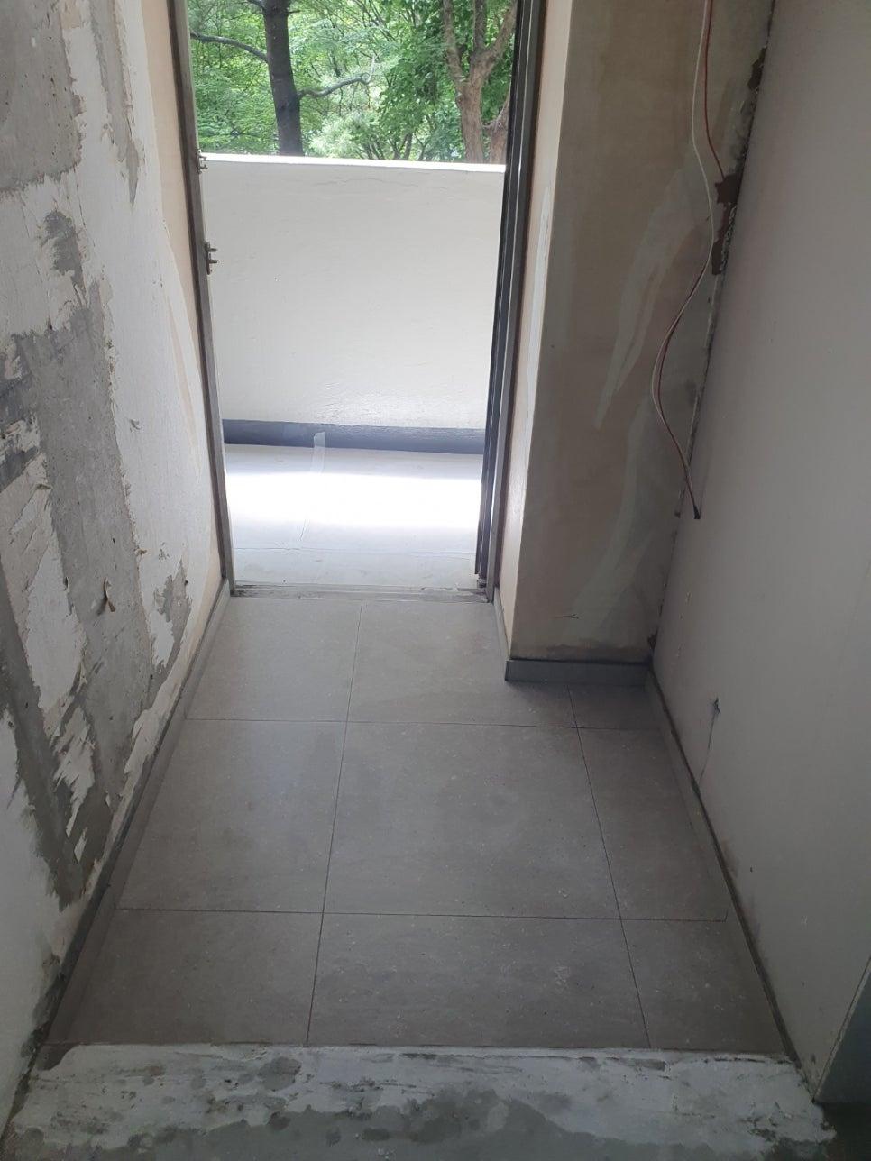 벽면 미장 작업이 진행 중인 복도 공간