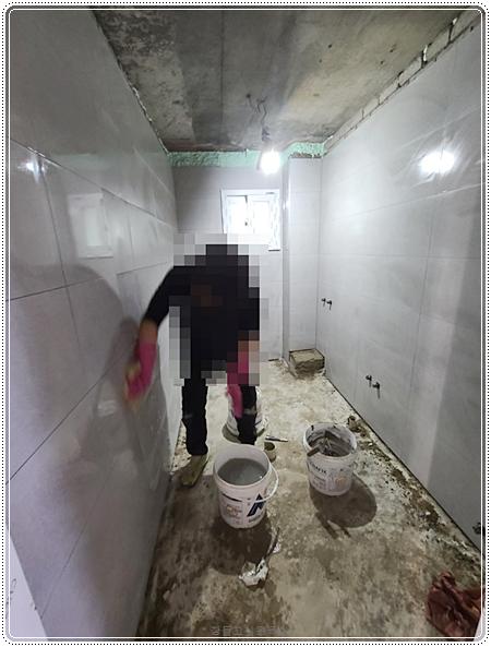 벽면 타일을 부착하며 줄눈 간격을 맞추는 모습