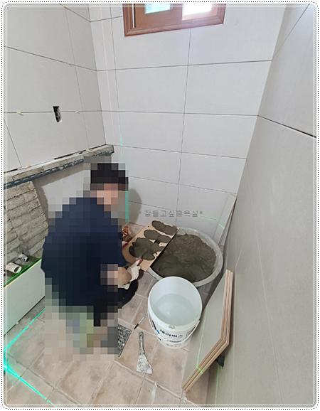 레이저 수평기로 라인을 맞춘 벽 타일 시공