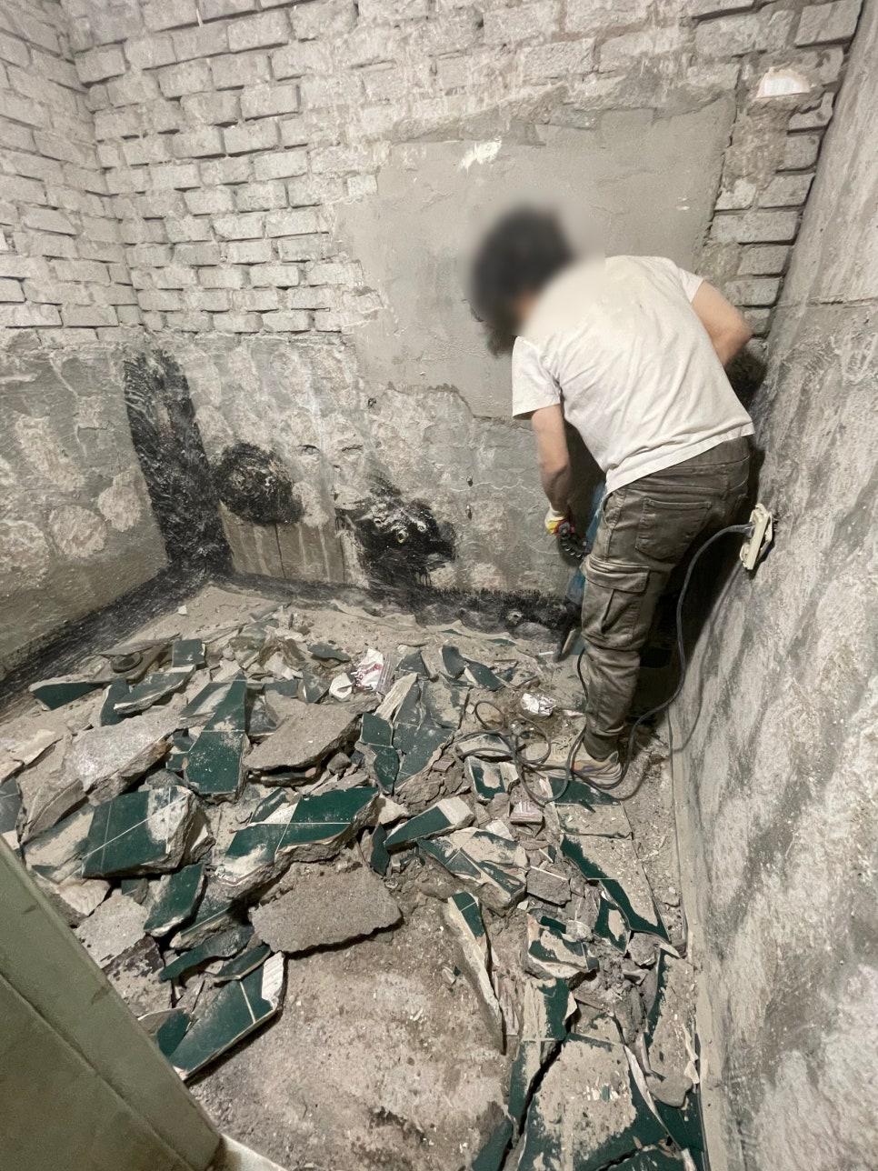 벽돌 벽과 파편이 흩어진 공사 중인 바닥