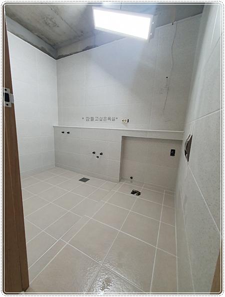 배수구와 전기 소켓 구멍이 보이는 바닥과 벽면