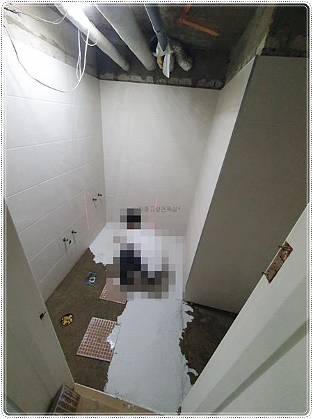 흰색 타일이 부착된 벽면과 노출된 천장