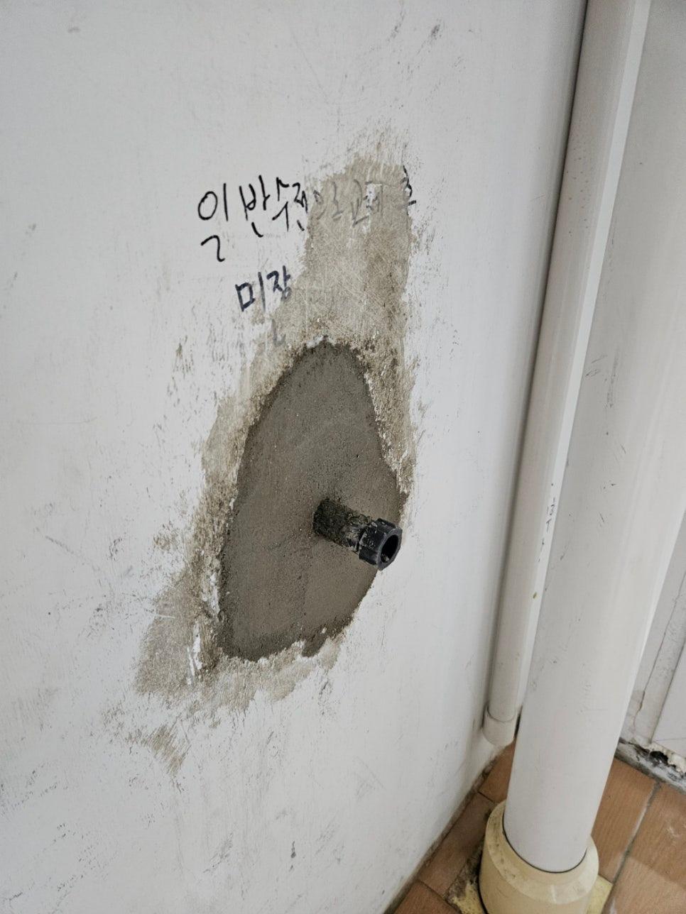 검은색 파이프가 삽입된 벽면의 미장 과정